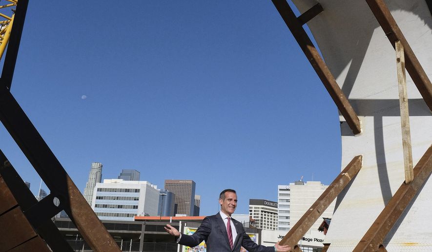 FILE - In this Oct. 19, 2016, file photo, Los Angeles Mayor Eric Garcetti stands inside a section of a tunnel boring machine before workers lower it into a 45-foot deep pit, during a ceremonial naming and lowering for the Regional Connector Transit Project in downtown Los Angeles, Calif. Garcetti's toughest competitor in his campaign for a second term might not be another candidate. The mayor shares the ballot with a proposal intended to restrict large real estate projects that challenges his vision for building thousands of new apartments clustered around train stations. (AP Photo/Richard Vogel, File)