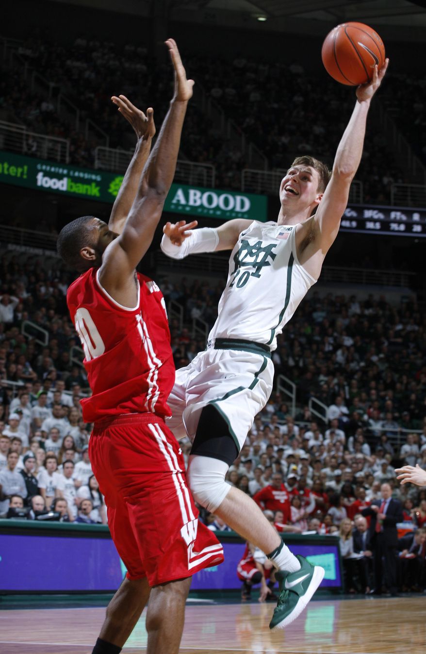 Michigan State&#39;s Matt McQuaid, right, shoots against Wisconsin&#39;s Vitto Brown during the second half of an NCAA college basketball game, Sunday, Feb. 26, 2017, in East Lansing, Mich. (AP Photo/Al Goldis)