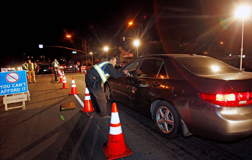In this Dec. 16, 2011 photo, police officers check drivers at a sobriety checkpoint in Escondido, Calif. Starting Jan. 1, 2012, police in California can no longer impound vehicles from DUI checkpoints when the driver&#x27;s only offense is driving without a license. The impounds have been controversial where critics say they are used to drive out illegal immigrants. The American Civil Liberties Union has questioned how much Escondido is making from illegal immigrants whose cars are impounded because they do not have drivers licenses.  (AP Photo/Lenny Ignelzi)