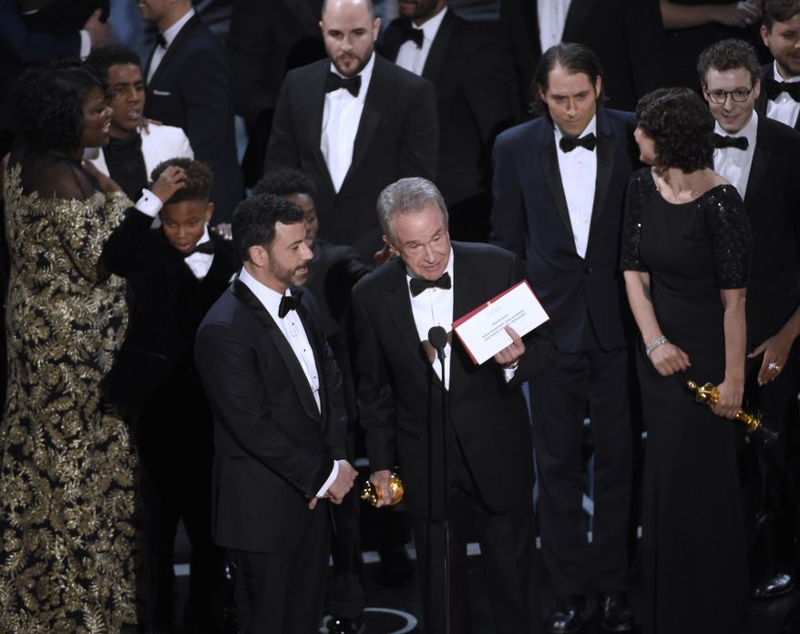 Presenter Warren Beatty shows the envelope with the actual winner for best picture as host Jimmy Kimmel, left, looks on at the Oscars on Sunday, Feb. 26, 2017, at the Dolby Theatre in Los Angeles. The winner was originally announced as "La La Land," but was later corrected to "Moonlight." (Photo by Chris Pizzello/Invision/AP)