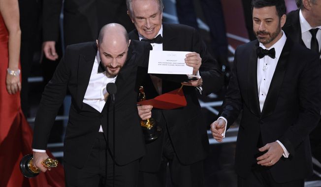 Jordan Horowitz, producer of &amp;quot;La La Land,&amp;quot; shows the envelope revealing &amp;quot;Moonlight&amp;quot; as the true winner of best picture at the Oscars on Sunday, Feb. 26, 2017, at the Dolby Theatre in Los Angeles. Presenter Warren Beatty and host Jimmy Kimmel look on from right. (Photo by Chris Pizzello/Invision/AP)