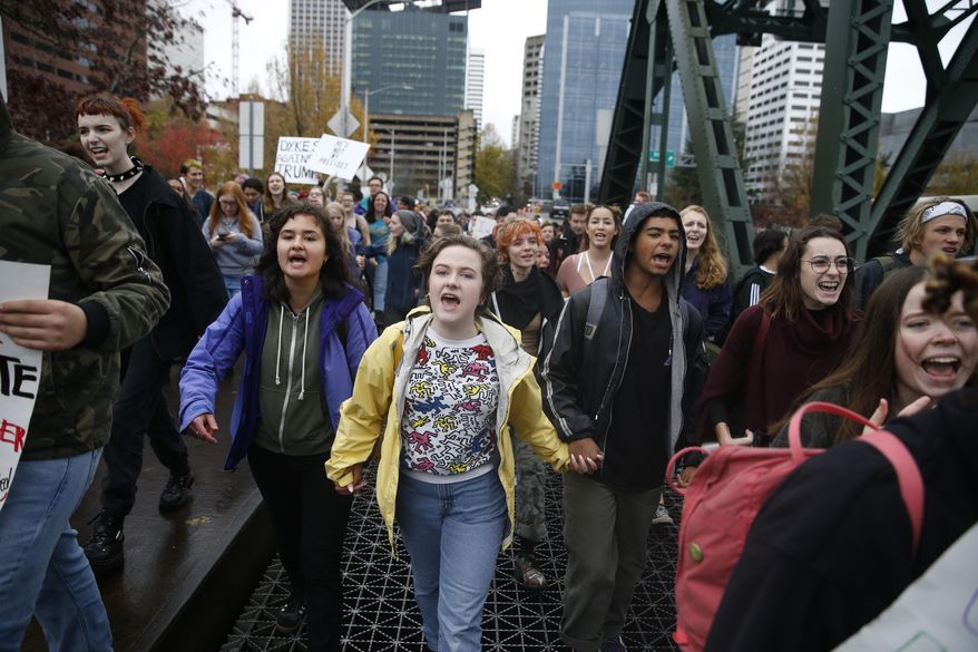 FILE--In this Nov. 14, 2016, file photo, Portland Public School students walk out of schools and converge on Pioneer Courthouse Square for a protest against the results of last week's presidential election. Almost 800 teenagers between the ages of 13 and 17 have participated in a first-of-its-kind Associated Press-NORC Center for Public Affairs poll on teens' social media use, political views and political outlook. (Beth Nakamura/The Oregonian via AP)