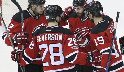 New Jersey Devils right wing Kyle Palmieri (21) celebrates his goal with teammates center Travis Zajac (19) defenseman Damon Severson (28) and defenseman John Moore (2) during the first period of an NHL hockey game against the Montreal Canadiens, Monday, Feb. 27, 2017, in Newark, N.J. (AP Photo/Mel Evans)