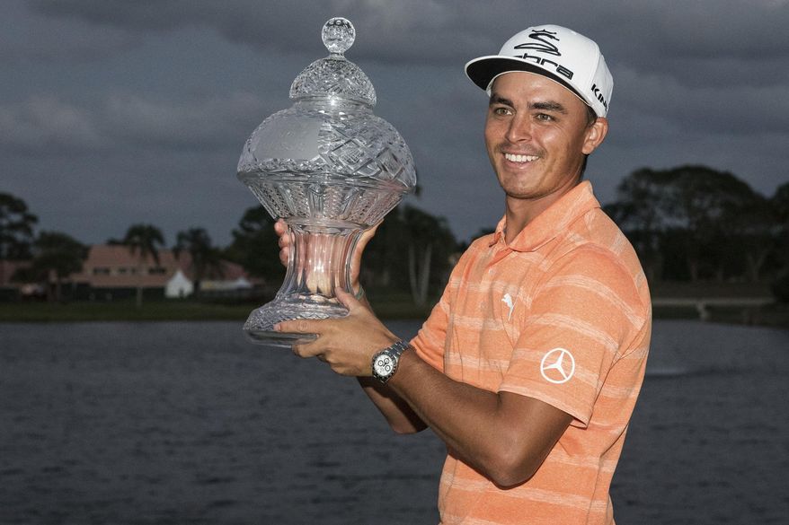 Golfer Rickie Fowler holds up the Honda Classic trophy after the conclusion of the golf tournament in Palm Beach Gardens, Fla., on Sunday, Feb. 26, 2017. (Michael Ares /The Palm Beach Post via AP)