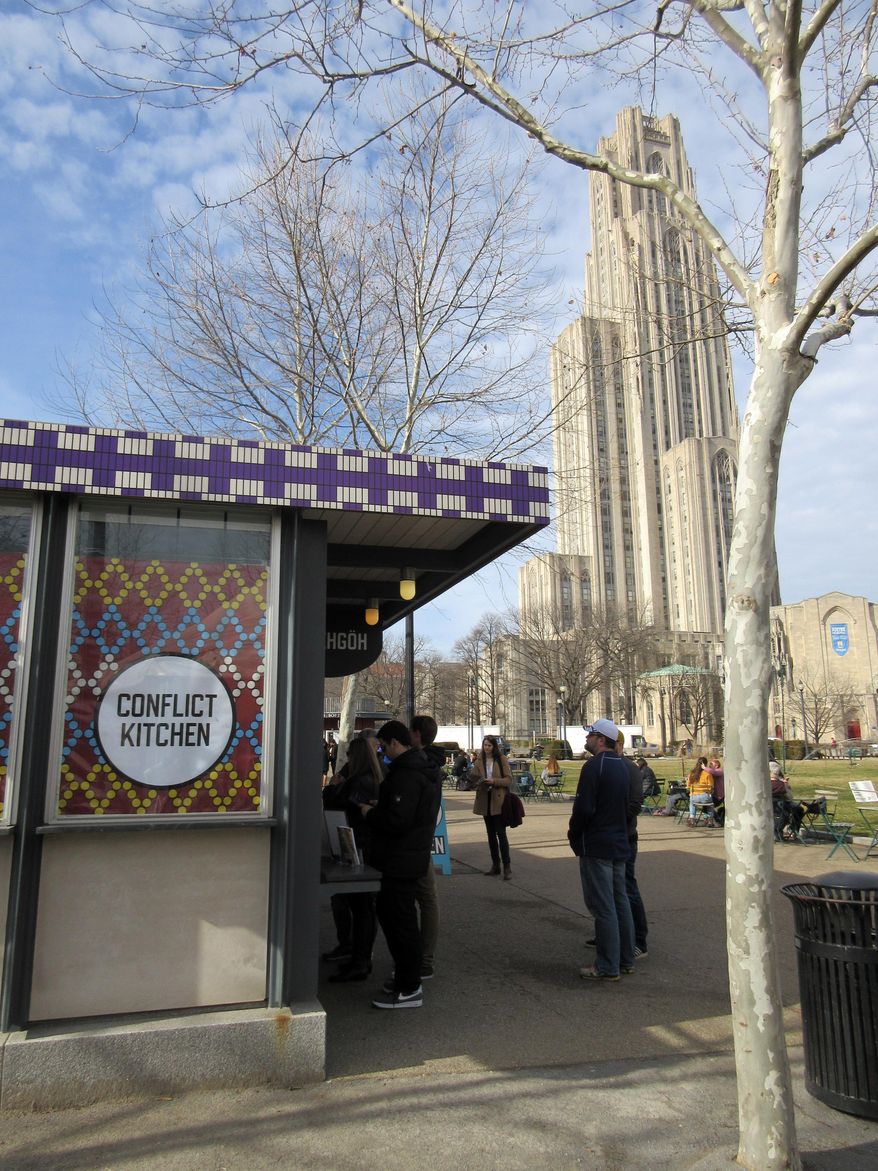This Feb. 17, 2017 photo shows the Conflict Kitchen in Pittsburgh with the University of Pittsburgh's Cathedral of Learning rising behind it. The Conflict Kitchen offers a changing menu inspired by the cuisine of nations with which the U.S. has been in conflict such as Iran and Cuba. (AP Photo/Beth J. Harpaz)