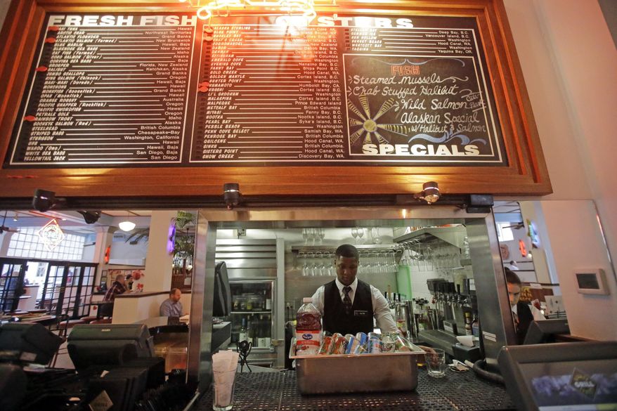 FILE - In this Feb. 10, 2017 file photo, Market Street Grill server Colton Prestwich works behind the Zion Curtain, in Salt Lake City. A Utah lawmaker is unveiling a proposal overhauling liquor laws and allowing restaurants to get rid of barriers known as "Zion Curtains" but in exchange require a type of buffer zone around bars or areas where drinks are prepared. The buffer zones would have to be 10 feet from the rest of the dining room or a waiting area and walled off and be off limits to anyone under 21 years old. (AP Photo/Rick Bowmer, File)
