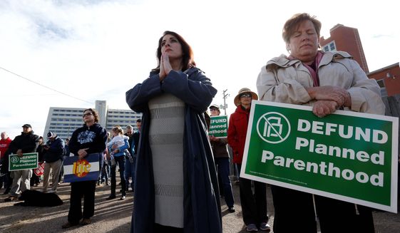 Participants in an anti-abortion rally hold signs and pray as they listen to a member of Christian clergy read from the Bible, in front of Planned Parenthood of the Rocky Mountains, in Denver, Saturday, Feb. 11, 2017. Anti-abortion activists emboldened by the new administration of President Donald Trump staged rallies around the country Saturday calling for the federal government to cut off payments to Planned Parenthood. (AP Photo/Brennan Linsley) (Associated Press)