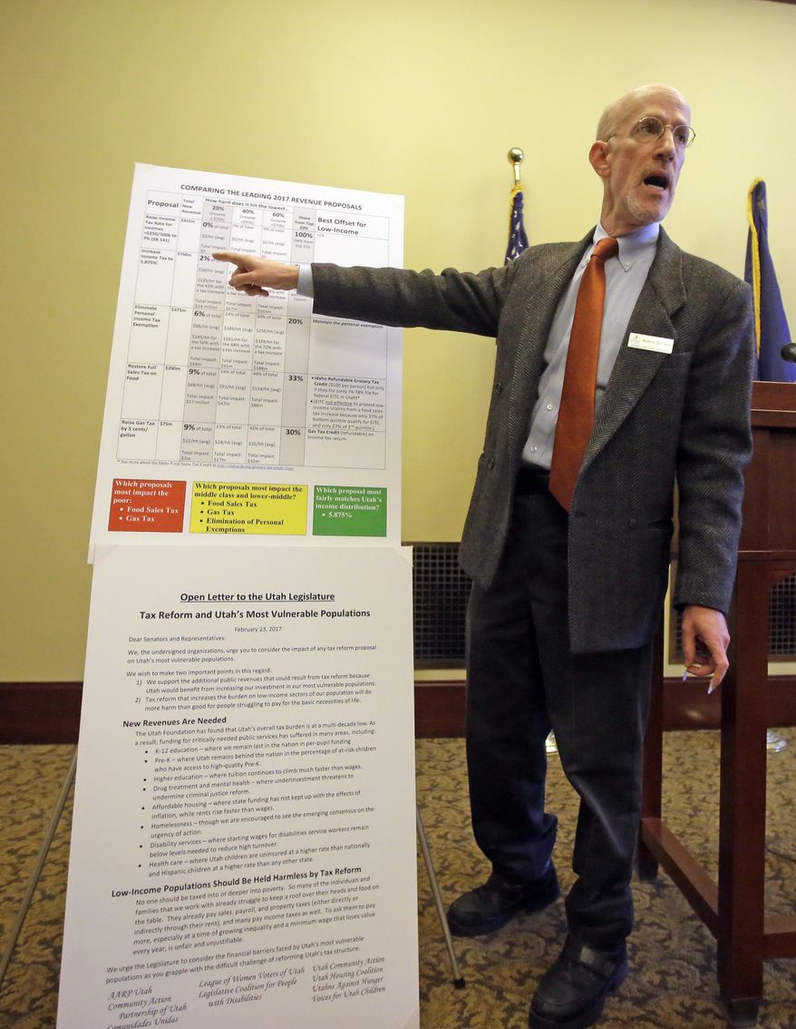 Matthew Weinstein, state priorities partnership director, points to a chart as he talks to members of the media during a news conference at the Utah State Capitol Thursday, Feb. 23, 2017, in Salt Lake City. As Utah lawmakers are debating plans to restructure and raise Utah's income and food taxes, advocates for the poor and working families on Thursday will weigh in on how much the various proposals could cost the needy. (AP Photo/Rick Bowmer)