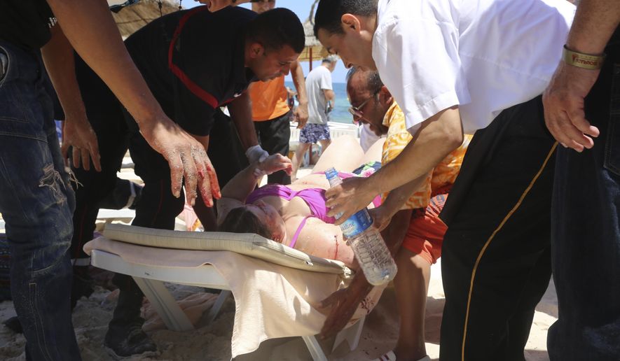 FILE - This is a Friday, June 26, 2015 file photo of an injured person being treated on a Tunisian beach, in Sousse Tunisia. A British coroner said the Tunisian police response to a deadly gun attack on the beach resort of Sousse was "at best shambolic, at worst cowardly." Judge Nicholas Lorraine-Smith is delivering his findings Tuesday Feb. 28, 2017 at an inquest into the deaths of 30 British tourists killed in the June 2015 attack at the five-star Riu Imperial Marhaba hotel. (Jawhare FM/File via AP)
