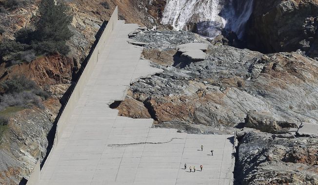 Officials inspect Oroville Dam&#x27;s crippled spillway Tuesday, Feb. 28, 2017, in Oroville, Calif. California water authorities stopped the flow of water down the spillway, Monday, allowing workers to begin clearing out massive debris that&#x27;s blocking a hydroelectric plant from operating. (AP Photo/Rich Pedroncelli)