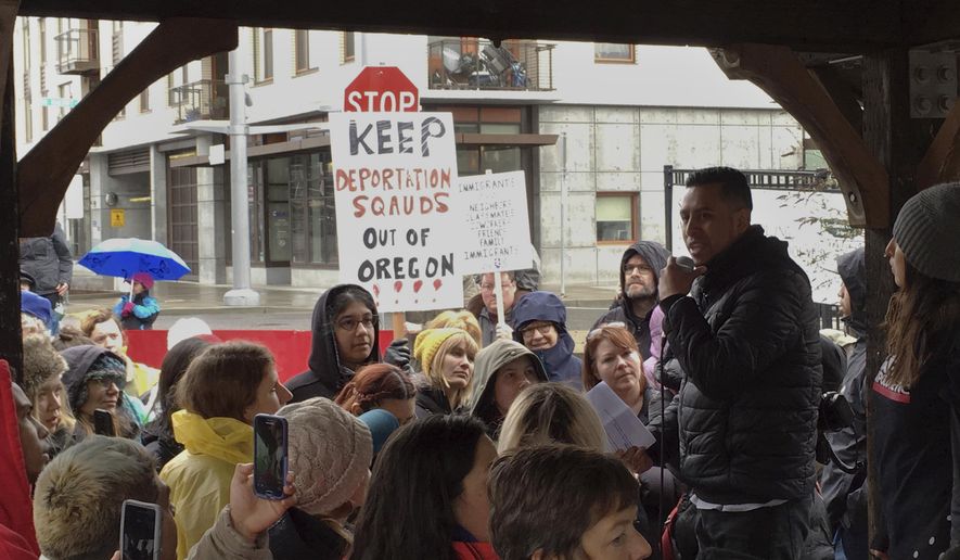 In this Monday, Feb. 27, 2017, photo, protesters gather during a rally outside an Immigration and Customs Enforcement office in Portland, Ore. Federal immigration officers stopped two vans carrying 19 workers headed to a forest in Oregon to pick an ornamental shrub and took 10 of them away, an activist said Tuesday. (AP Photo/Andrew Selsky)