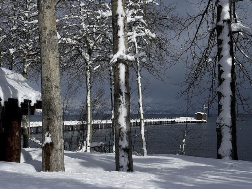 The pier in the background of this photograph taken at Lake Tahoe in Tahoe City, Calif., on Feb. 23, 2017 was standing in only a few inches of water in the summer of 2015. The drought-busting snow and rain in the mountains around Tahoe this winter have pushed the lake's level to its highest mark in more than a decade. (Jason Bean/The Reno Gazette-Journal via AP)