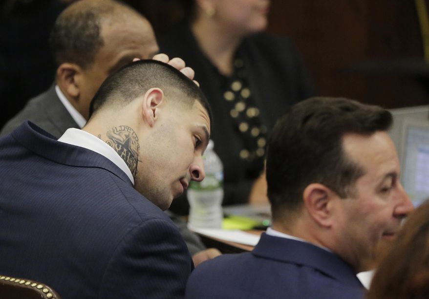 Former New England Patriots tight end Aaron Hernandez rubs his head as he sits with his attorneys on the fist day of his double murder trial at Suffolk Superior Court on Wednesday, March 1, 2017, in Boston. Hernandez is standing trial for the July 2012 killings of Daniel de Abreu and Safiro Furtado who he encountered in a Boston nightclub. He is already serving a life sentence in the 2013 killing of semi-professional football player Odin Lloyd. (AP Photo/Stephan Savoia, Pool)