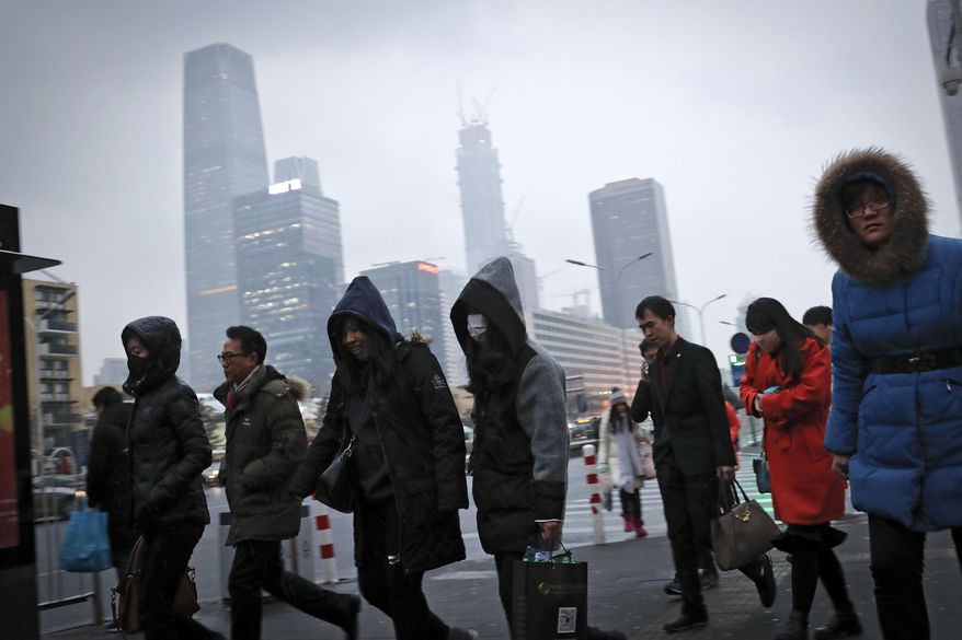 In this Feb. 21, 2017 photo, commuters, some wearing masks, walk to a subway station to a subway station during the evening rush hour in Beijing. Yet the city’s average reading of the tiny particulate matter PM2.5 - considered a good gauge of air pollution - is still seven times what the World Health Organization considers safe. A group of Chinese lawyers is suing the governments of Beijing and its surrounding areas for not doing enough to get rid of the smog. (AP Photo/Andy Wong)