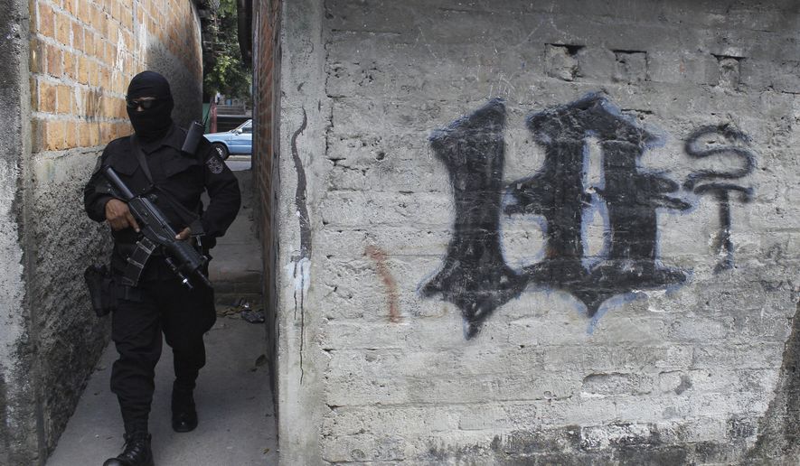 FILE - This April 5, 2016 file photo shows a masked, armed police officer patrolling a gang controlled neighborhood in San Salvador, El Salvador. Government statistics show a sharp drop in homicides so far in 2017 after the gang-plagued country posted some of the world's highest murder rates in recent years, according to National police Commissioner Howard Cotto on March 1, 2017. (AP Photo/Alex Peña, File)