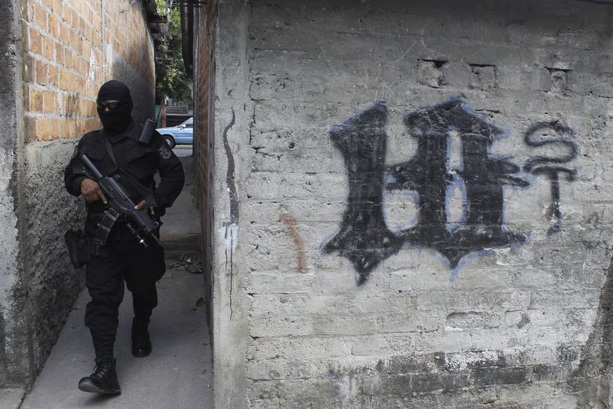 FILE - This April 5, 2016 file photo shows a masked, armed police officer patrolling a gang controlled neighborhood in San Salvador, El Salvador. Government statistics show a sharp drop in homicides so far in 2017 after the gang-plagued country posted some of the world's highest murder rates in recent years, according to National police Commissioner Howard Cotto on March 1, 2017. (AP Photo/Alex Peña, File)