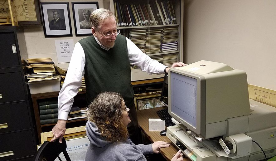 This photo taken Feb. 24, 2017, shows Monongahela architect and historian Terry Necciai examining an 1893 edition of The Daily Republican with Monongahela Area Library Director Tiffany Fleet in Monongahela, Pa. (Scott Beveridge /Observer-Reporter via AP)