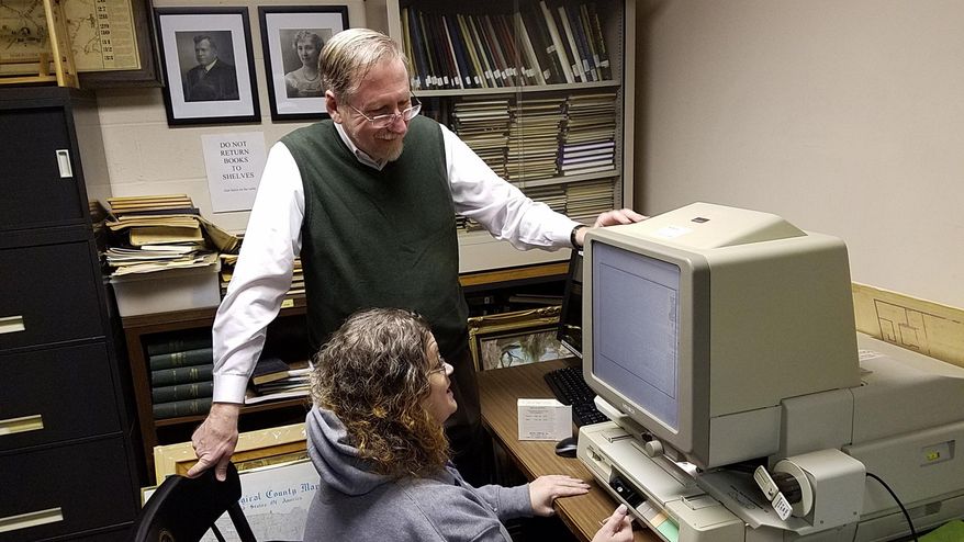 This photo taken Feb. 24, 2017, shows Monongahela architect and historian Terry Necciai examining an 1893 edition of The Daily Republican with Monongahela Area Library Director Tiffany Fleet in Monongahela, Pa. (Scott Beveridge /Observer-Reporter via AP)
