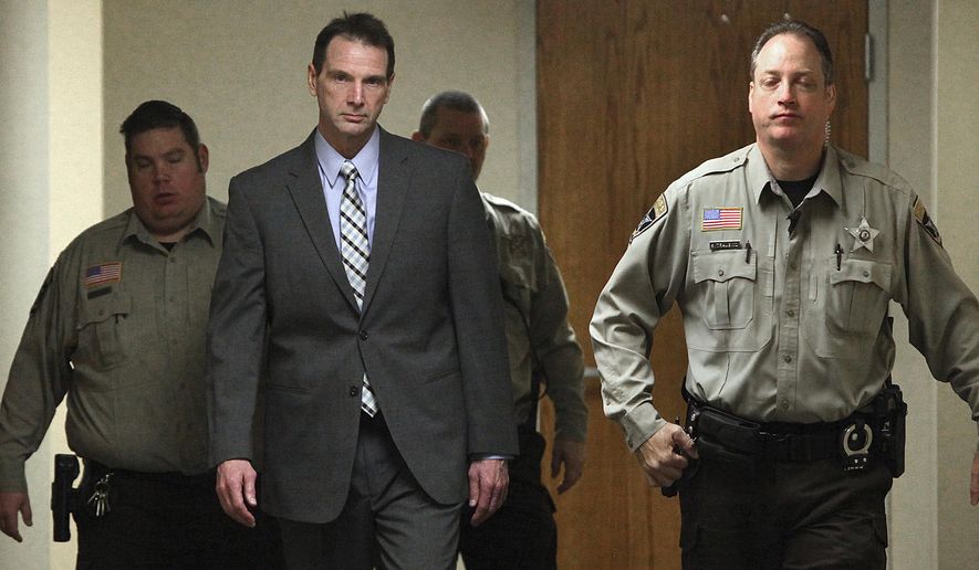 FILE - In this Jan. 25, 2016 file photo Curtis Lovelace, center, is escorted by sheriff's deputies to a courtroom at the Adams County Courthouse in Quincy, Ill. Lovelace, a former University of Illinois football star and Adams County prosecutor, is to go to trial a second time for first-degree murder in his first wife's death. Jury selection is scheduled to begin Tuesday, Feb. 28, 2017, in Springfield, Ill. (Phil Carlson/The Quincy Herald-Whig via AP File)