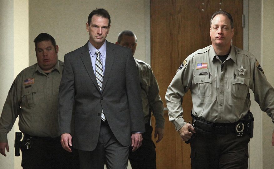 FILE - In this Jan. 25, 2016 file photo Curtis Lovelace, center, is escorted by sheriff's deputies to a courtroom at the Adams County Courthouse in Quincy, Ill. Lovelace, a former University of Illinois football star and Adams County prosecutor, is to go to trial a second time for first-degree murder in his first wife's death. Jury selection is scheduled to begin Tuesday, Feb. 28, 2017, in Springfield, Ill. (Phil Carlson/The Quincy Herald-Whig via AP File)