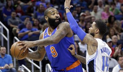 New York Knicks&#x27; Kyle O&#x27;Quinn, left, looks to pass the ball around Orlando Magic&#x27;s D.J. Augustin (14) during the first half of an NBA basketball game, Wednesday, March 1, 2017, in Orlando, Fla. (AP Photo/John Raoux)