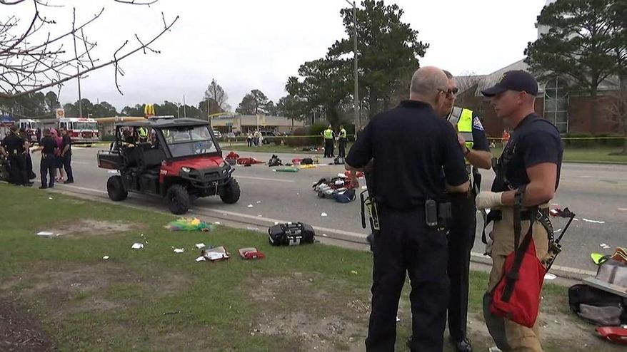 In this image made from a video provided by FOX10 News authorities talk near the scene after an SUV driven by a 73-year-old man accelerated and hit members of a high school band at the start of a Mardi Gras parade in Gulf Shores, Ala., Tuesday, Feb. 28, 2017. (Franz Barraza/FOX10 News via AP) MANDATORY CREDIT