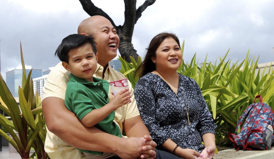 FILE - In this Feb. 24, 2017, file photo, Peyton Valiente, 3, sits with his parents Rey and Chelsea Valiente as they speak to The Associated Press in Honolulu, Hawaii. The Valiente's believe a baby sitter's police connection is the reason there have been no arrests two years after their son, Peyton, suffered a brain injury from forceful shaking. (AP Photo/Caleb Jones, file)