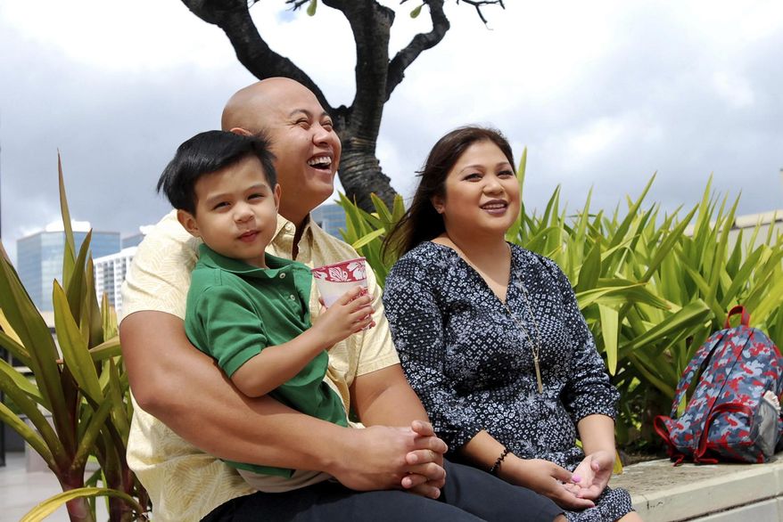 FILE - In this Feb. 24, 2017, file photo, Peyton Valiente, 3, sits with his parents Rey and Chelsea Valiente as they speak to The Associated Press in Honolulu, Hawaii. The Valiente's believe a baby sitter's police connection is the reason there have been no arrests two years after their son, Peyton, suffered a brain injury from forceful shaking. (AP Photo/Caleb Jones, file)