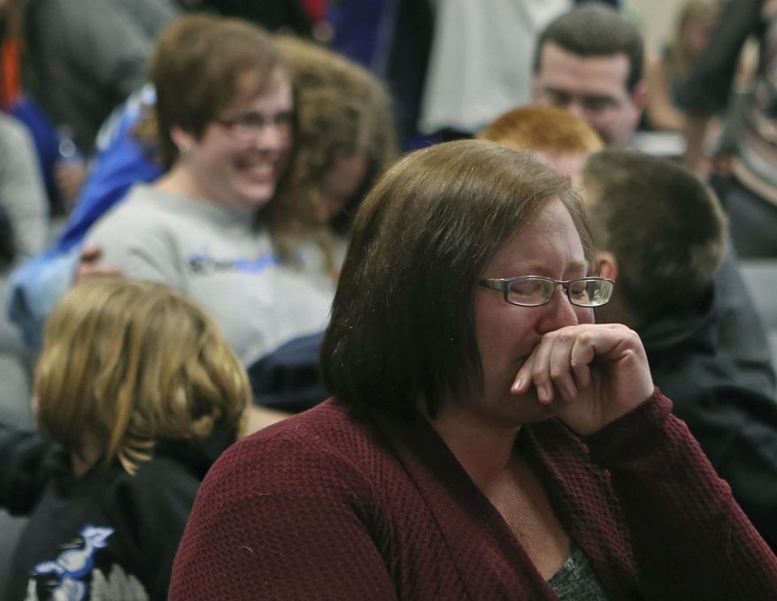In this Tuesday, Feb. 28, 2017 photo, a woman is emotional following the Council Bluffs Community School District Board of Education's decision to vote down the district's proposal to close Crescent Elementary School, in Council Bluffs, Iowa. (Joe Shearer/ The Daily Nonpareil via AP)