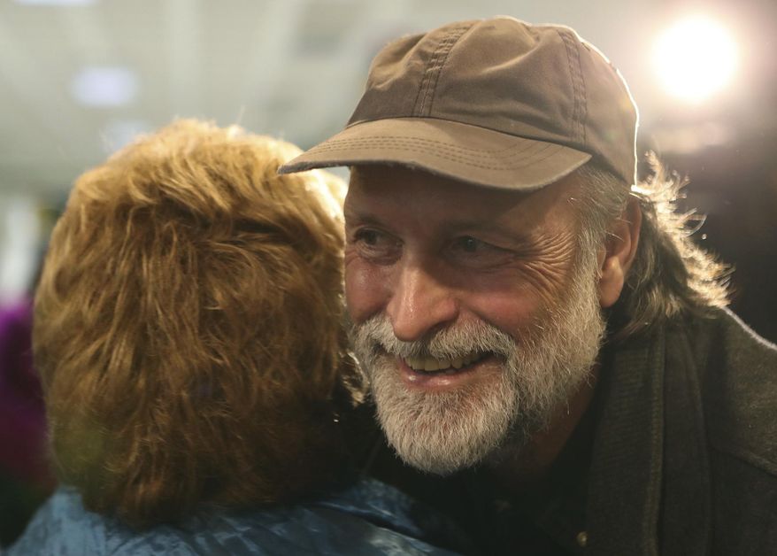 In this Tuesday, Feb. 28, 2017 photo, Shawn Shea of Crescent, an opponent of the Council Bluffs Community School District's proposal to close Crescent Elementary School, hugs a fellow proponent of the school following the school board's decision to vote down the proposal, in Council Bluffs, Iowa. (Joe Shearer /The Daily Nonpareil via AP)