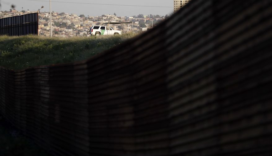 A Border Patrol vehicle sits along a section of border fencing that separates Tijuana, Mexico, with San Diego on Tuesday, Feb. 28, 2017, in San Diego. President Donald Trump, signaling a potential shift on a signature issue, indicated Tuesday that he's open to immigration legislation that would give legal status to some people living in the U.S. illegally and provide a pathway to citizenship to those brought to the U.S. illegally as children. (AP Photo/Gregory Bull)