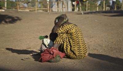 In this photo taken Thursday, Feb. 16, 2017, a South Sudanese refugee woman sits with her child at a refugee collection center in Palorinya, Uganda. More than 100,000 people have fled a single county in South Sudan in just three months as civil war continues amid warnings of genocide, and the surge of more than half a million South Sudanese refugees into Uganda since July has created Africa&#39;s largest refugee crisis. (AP Photo/Justin Lynch)