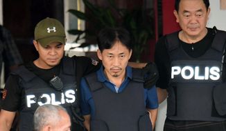 North Korean Ri Jong-chol, center, who was arrested in connection with the death of Kim Jong-un&#x27;s half-brother, is transferred from Sepang district police station in Sepang, Malaysia on Friday, March 3, 2017. Earlier Thursday, Malaysian authorities said they will release Ri from custody Friday because of a lack of evidence. (Muneyoshi Someya/Kyodo News via AP)