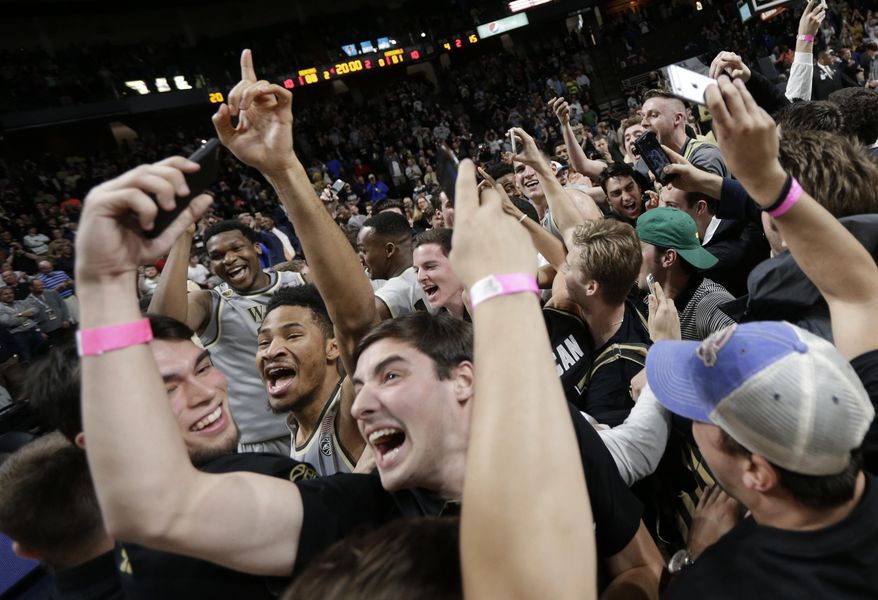 Wake Forest students and players celebrate after the team's NCAA college basketball game against Louisville in Winston-Salem, N.C., Wednesday, March 1, 2017. Wake Forest won 88-81. (AP Photo/Chuck Burton)