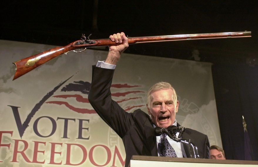 Then-National Rifle Association President Charlton Heston holds up a rifle as he addresses gun owners during a "get-out-the-vote" rally in Manchester, N.H., in this Oct. 21, 2002, file photo. A Philadelphia judge's clash with the late actor has indirectly led to a U.S. appeals court decision to overturn a 1998 murder conviction. (AP Photo/Jim Cole, File)