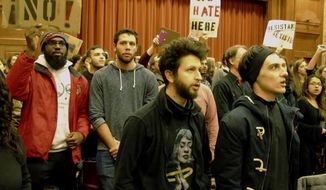 Middlebury College students turn their backs to Charles Murray, unseen, who they call a white nationalist, during his lecture in Middlebury, Vt., Thursday, March 2, 2017. Hundreds of college students on Thursday protested a lecture by a speaker they call a white nationalist, forcing the college to move his talk to an undisclosed campus location from which it was live-streamed to the original venue but couldn&#39;t be heard above protesters&#39; chants, feet stamping and occasional smoke alarms. (AP Photo/Lisa Rathke)