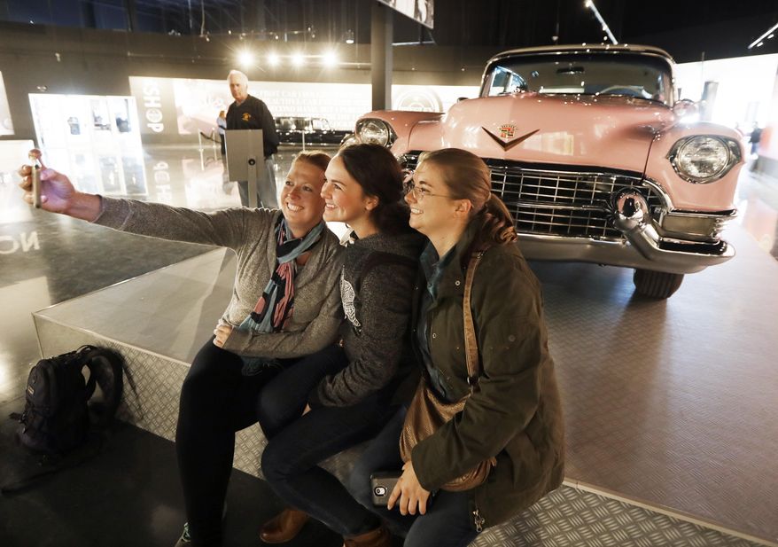 Visitors take a selfie in front of Elvis Presley's pink 1955 Cadillac Fleetwood on display at the "Elvis Presley's Memphis" complex Thursday, March 2, 2017, in Memphis, Tenn. The complex features a comprehensive Presley exhibit with clothing he wore on stage and guitars he played; a showcase of the cars he owned and used; a soundstage; a theater; two restaurants and retail stores. (AP Photo/Mark Humphrey)