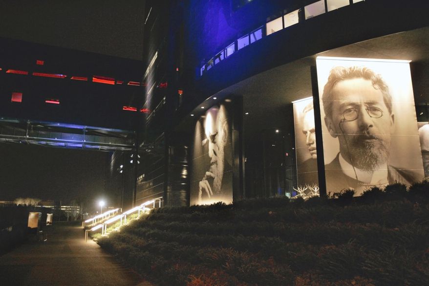 FILE - In a April 24, 2007 file photo, photos of playwrights George Bernard Shaw, left, Eugene O'Neill, center and Anton Chekhov, grace the facade in a night view of the new Guthrie Theater in Minneapolis. The Minneapolis theater announced seven of its upcoming nine productions Thursday, March 2, 2017. The Guthrie Theater's new season will explore contemporary issues such as race relations and cultural assimilation. (AP Photo/Jim Mone, File)