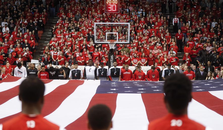 The Cincinnati men's basketball team holds a large U.S. flag as the national anthem is played on senior night before the team's NCAA college basketball game against Houston, Thursday, March 2, 2017, in Cincinnati. (AP Photo/John Minchillo) ** FILE **