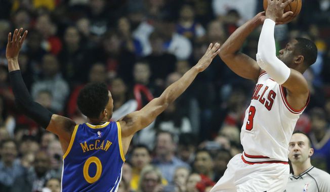 Chicago Bulls guard Dwyane Wade, right, shoots against Golden State Warriors guard Patrick McCaw during the first half of an NBA basketball game Thursday, March 2, 2017, in Chicago. (AP Photo/Nam Y. Huh)
