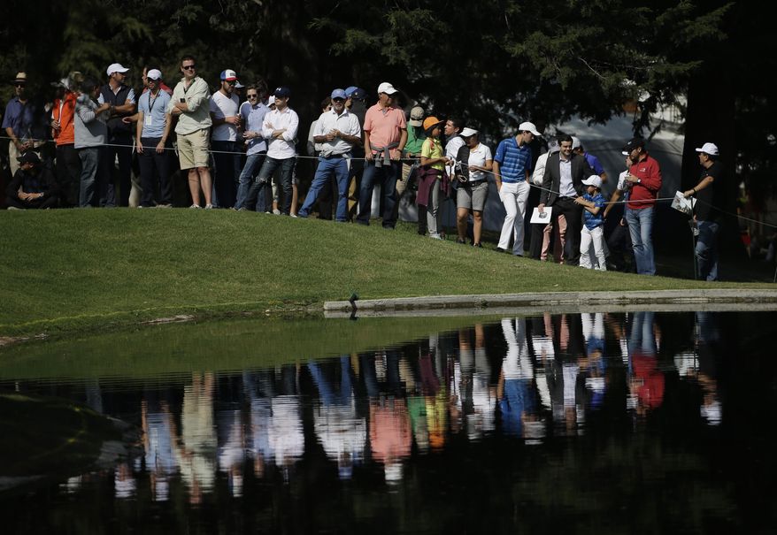 Spectators watch across a lake at the 6th hole, during round one of the Mexico Championship at Chapultepec Golf Club in Mexico City, Thursday, March 2, 2017. All but one of the world's top 50 golfers are contesting the World Golf Championship PGA event, which this year relocated to Mexico City from the Trump National Doral Resort in Florida. (AP Photo/Rebecca Blackwell)