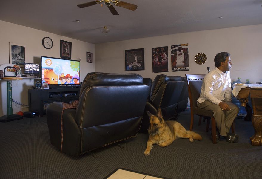 ADVANCE FOR THE WEEKEND OF MARCH 4-5 AND THEREAFTER - In a Feb. 21, 2017 photo, Ken Sah's living quarters in the hotel he owns are a lot different now than when he lived there over 10 years ago. Sah eats his bagel, seated at a pool table, in the apartment surrounded by posters of LeBron James and cartoons playing on the television. Ken and Sarita Sah, were forced to leave the country in 2006 after losing their legal battle with U.S. Immigration authorities. Their son Kunal has been running the family's hotel business in Green River since 2011, trying to keep his parents' dream alive without them. (Leah Hogsten/The Salt Lake Tribune via AP)