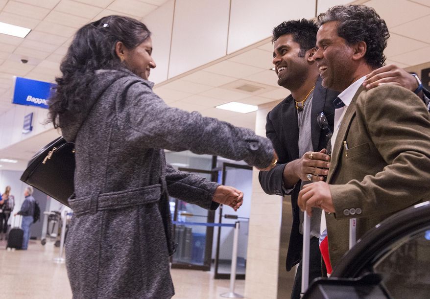 ADVANCE FOR THE WEEKEND OF MARCH 4-5 AND THEREAFTER - In a Feb. 21, 2017 photo, Sarita Sah greets her husband Ken, right, for the first time in over three weeks since she left India as Kunal Sah, 23, second right, welcomes his father, Ken Sah, back to the U.S. for the first time in over 10 years at the Salt Lake International Airport. Kunal's parents, Ken and Sarita Sah, were forced to leave the country in 2006 after losing their legal battle with U.S. Immigration authorities. Kunal has been running the family's hotel business in Green River since 2011, trying to keep his parents' dream alive without them. (Leah Hogsten/The Salt Lake Tribune via AP)