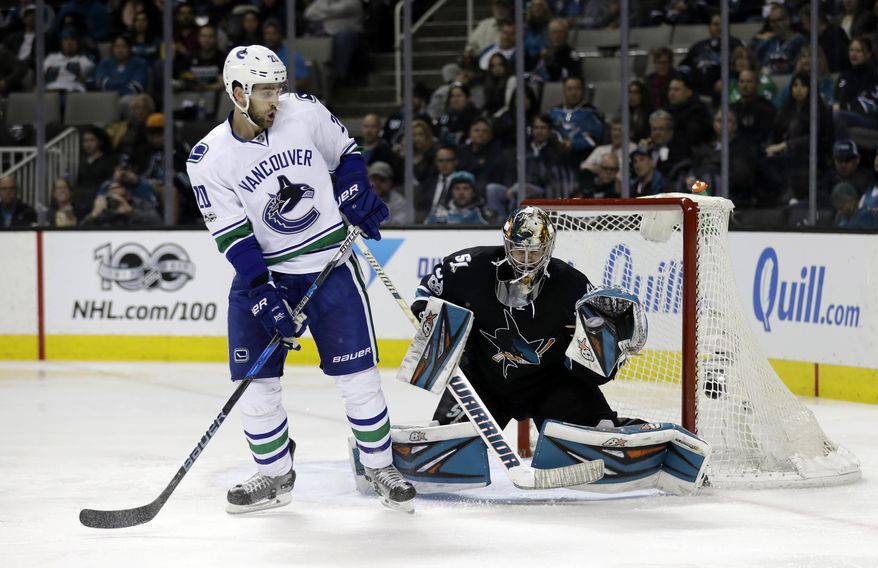 San Jose Sharks goalie Aaron Dell, right, stops a shot next to Vancouver Canucks center Brandon Sutter during the second period of an NHL hockey game Thursday, March 2, 2017, in San Jose, Calif. (AP Photo/Marcio Jose Sanchez)