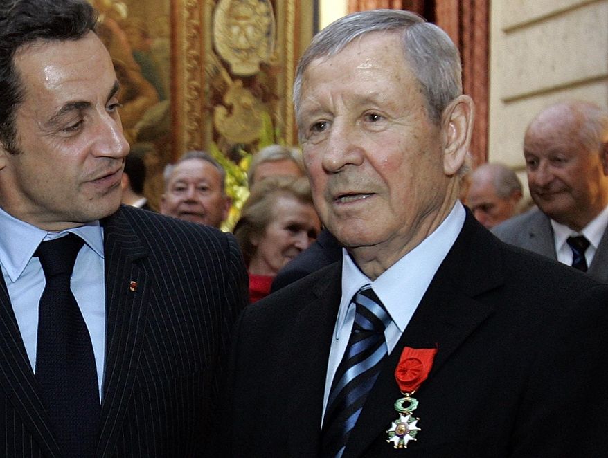 FILE - In this March 17, 2008 file photo, then French President Nicolas Sarkozy, left, talks with French former soccer legend Raymond Kopa after he was awarded Officer de la Legion d'Honneur, or Legion of Honor, in Paris.Former France and Real Madrid attacking midfielder Raymond Kopa, the first French player to win the Ballon d'Or, has died. He was 85. (AP Photo/Christophe Ena, Pool, File)