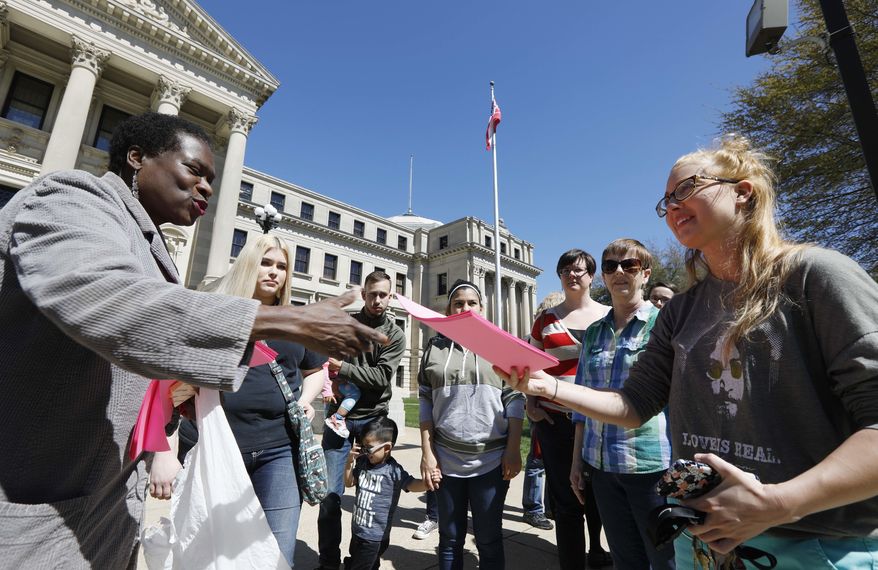 Patricia Ice, an attorney with the Mississippi Immigrants Rights Alliance, left, hands out flyers to Jordan Sanders of Vicksburg, that call for the freeing of 22-year old Daniela Vargas, a Argentine native who has lived in the United States since she was seven years old, following a brief rally on her behalf, at the Capitol in Jackson, Miss., Friday, March 3, 2017, Vargas was detained, March 1, by immigration agents who state that she is a "unlawfully present Argentinian citizen" during a "targeted immigration enforcement action." (AP Photo/Rogelio V. Solis)