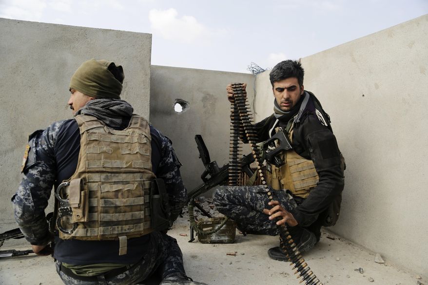 Iraqi federal police forces man a position on a roof of a house in on the edge of Mosul's Mamun neighborhood on Friday, March 3, 2017. Iraqi forces are still fighting to secure a belt of districts along the city's southwestern edge after launching an operation to retake western Mosul from the Islamic State group nearly two weeks ago. (AP Photo/Susannah George)