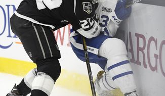 Los Angeles Kings center Trevor Lewis, left, puts Toronto Maple Leafs defenseman Alexey Marchenko, of Russia, into the boards during the second period of an NHL hockey game, Thursday, March 2, 2017, in Los Angeles. (AP Photo/Mark J. Terrill)