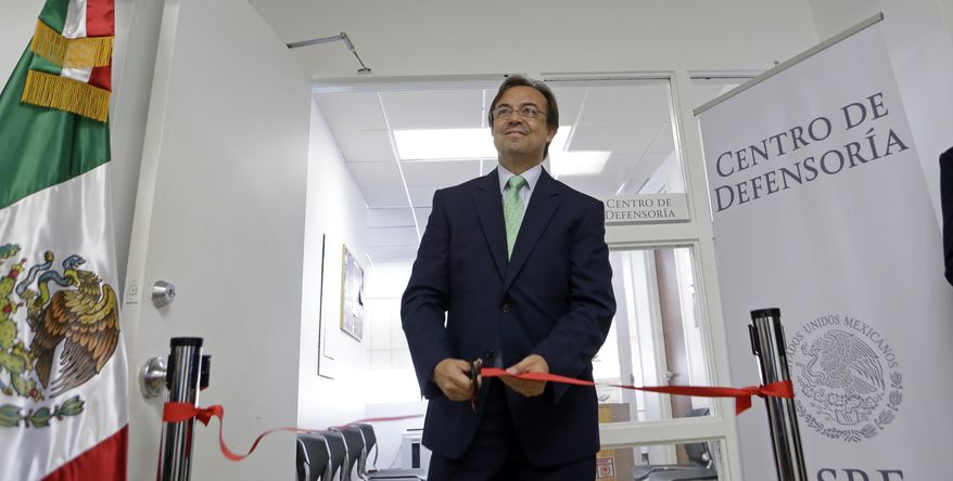 Mexican Consul General Jose Antonio Zabalgoitia cuts a ribbon at the opening of a legal Defense Center at the Mexican Consulate General, Friday, March 3, 2017, in Miami. The Mexican government is beefing up its aid to migrants in the U.S. through the creation of 50 legal assistance centers in response to President Donald Trump's measures to curb illegal immigration. (AP Photo/Alan Diaz)