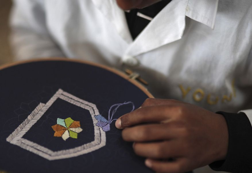 In this photo dated Tuesday, Feb. 28, 2017, a boy learns embroidery in an informal school run by Moroccan fashion designer Fadila El Gadi, in Sale, near Rabat, Morocco. A globally successful Moroccan fashion designer returned to her hometown and founded an unusual sewing school aimed at helping poor, troubled children find a path, in a country where youth unemployment is high and the lure of extremism lurks. (AP Photo/Mosa'ab Elshamy)